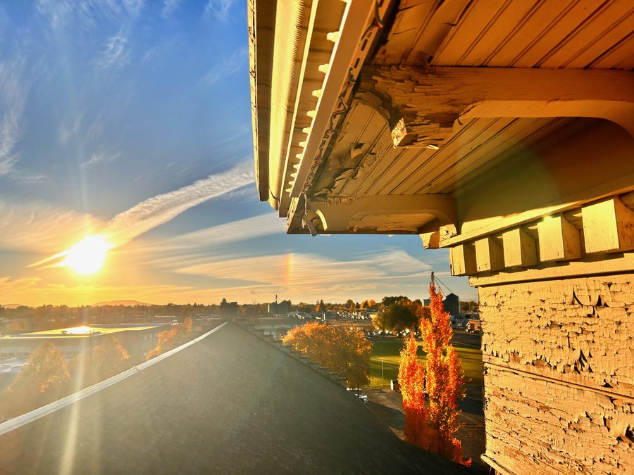 Warm sunset seen from the Tabernacle roofline beside the stone exterior.