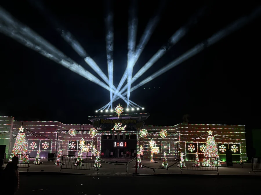 Noel at Rexburg Rapids covers the water park facade in Christmas imagery beneath white sky beams during the 2025 season.